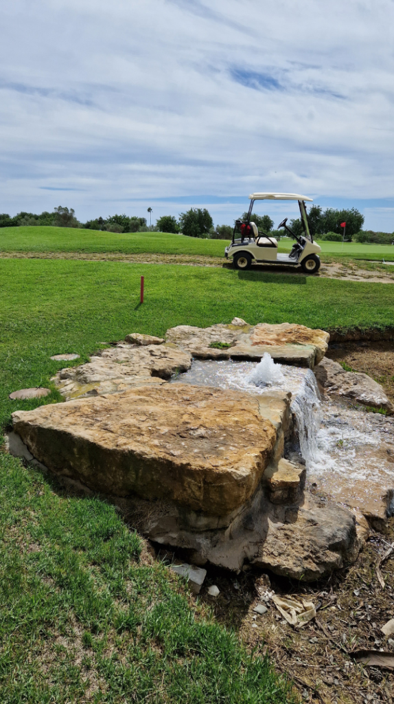 Golfanlage mit Springbrunnen und Golfcart